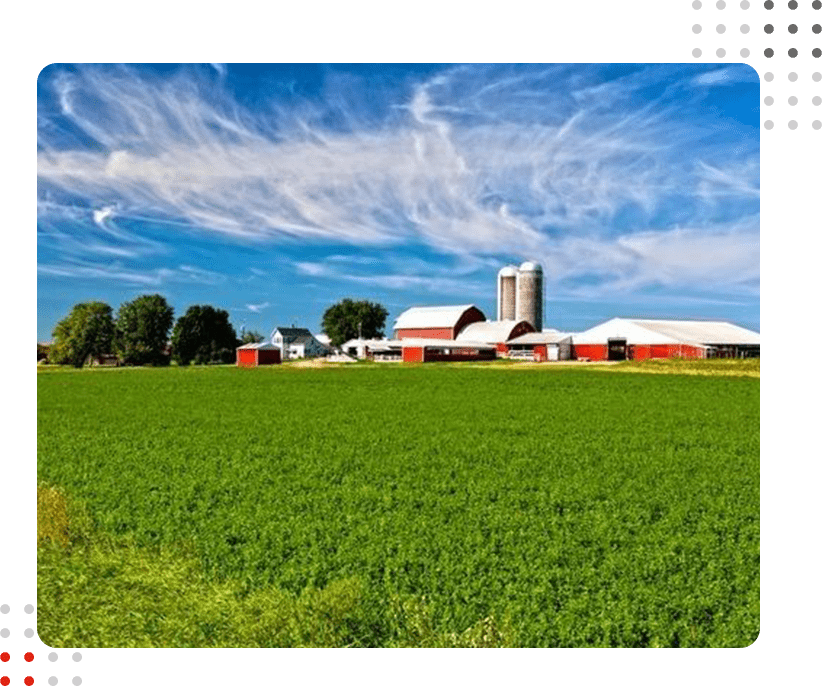 An image of a farm with a silo in the background.