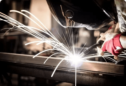 A welder working with sparks in a factory.